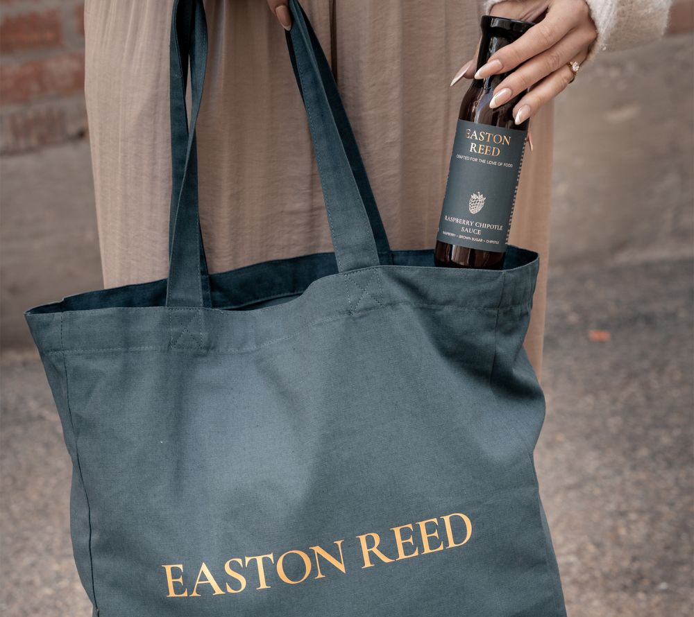 Easton Reed Tote Bag aus 100 % recycelter Baumwolle in Signature-Farbe mit Rose-Gold-Schriftzug. Stilvoll, praktisch und ideal als Geschenk oder Markenaccessoire.